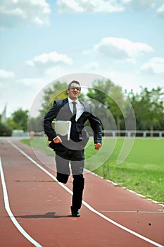Businessman running fast on athletic track in work stress and urgency concept