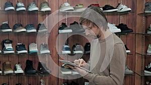 Businessman Running Online Shoe Business With Digital Tablet, standing in sneaker extreme shop