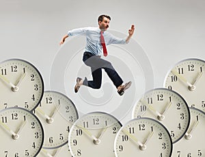 Businessman running over alarm clock.