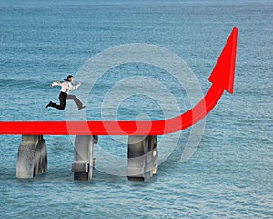 Businessman running on red trend arrow bridge