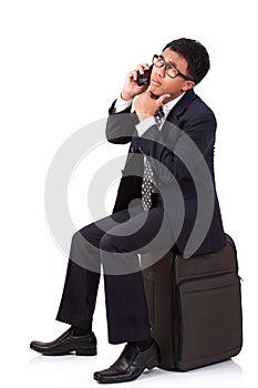 Businessman running with suitcase and using telephone