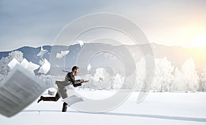 Businessman running in winter countryside