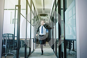 Businessman rushing and running on office hallway photo