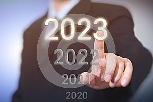 Businessman`s finger pointing to 2023. New year business concept