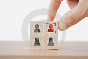 Hand choose red person and focus sign on wooden cube block for human resource, outstanding leadership concept