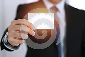 Businessman`s hand holding business card with empty space, close-up