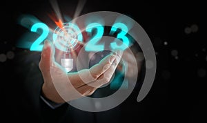 Businessman`s hand holding the year 2023 with light blub, dart, and target. Starting new year, business, project, path, goal, or