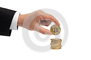 Businessman`s hand holds a gold coin bitcoin coin. Isolated on white background.