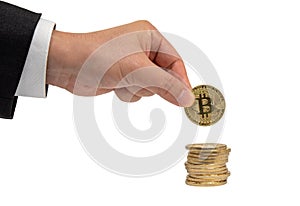 Businessman`s hand holds a gold coin bitcoin coin. Isolated on white background.