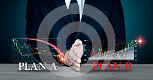 A businessman's hand obstructs PLAN A. PLAN B wording on the table backdrop has been changed. Concepts such as strategy. photo