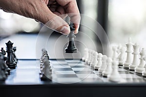 Businessman`s hand playing chess game to development analysis ne
