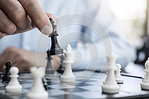 Businessman`s hand playing chess game to development analysis ne