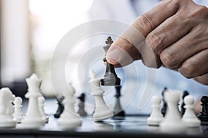 Businessman`s hand playing chess game to development analysis ne