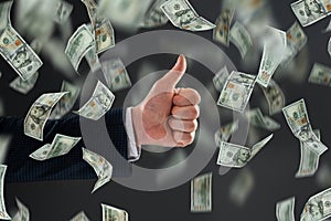 Businessman`s hand shows thumbs up against the background of falling dollars. The concept of investments, dividends, interest,