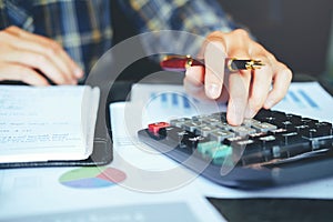 Businessman`s hands with calculator at the office and Financial