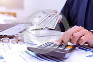 Businessman`s hands with calculator at the office and Financial data analyzing counting