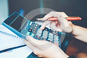 Businessman`s hands with calculator at the office and Financial data Cost Economic.