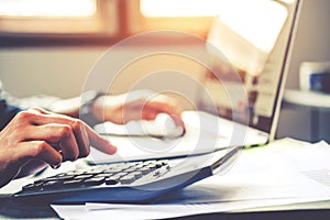 Businessman`s hands with calculator at the office and Financial data Cost Economic