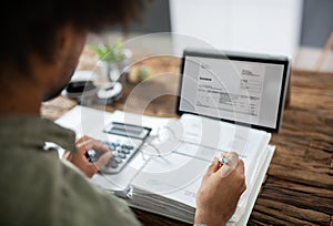 Businessman`s Hands Working On Invoice On Laptop