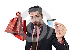 Businessman in Santa Claus Christmas hat holding sopping bags and credit card in worried and stress