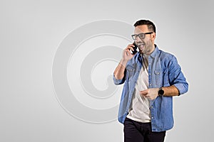 Businessman screaming ecstatically while listening good news over mobile phone on white background