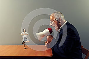 Businessman screaming at small smiley woman