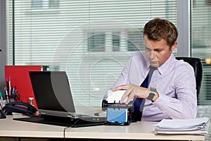 Businessman searching for card by laptop in office