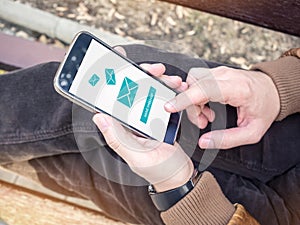 Businessman sending email message via modern smartphone