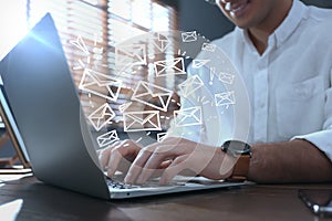 Businessman sending emails at table, closeup