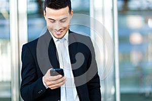 Businessman sending a sms outdoor