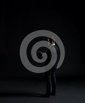 Businessman sending sms with a smartphone. Black background