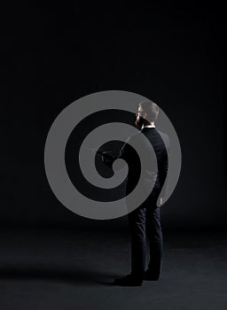 Businessman sending sms with a smartphone. Black background with