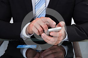 Businessman sending a text message or sms