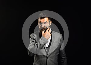 Businessman with serious face isolated on black background.