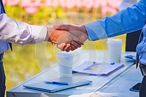 Businessman,They are shake hands in park.They are talking business.