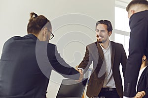 Businessman shakes hands with a new team member and congratulates the partner on a successful deal.