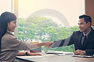 Businessman shaking hands with Businesswoman at meeting