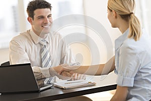 Businessman Shaking Hands With Colleague During Meeting In Office