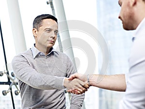 Businessman shaking hands with competitor