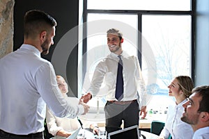 Businessman shaking hands to seal a deal with his partner and colleagues in office