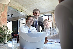 Businessman shaking hands to seal a deal with his partner and colleagues in office