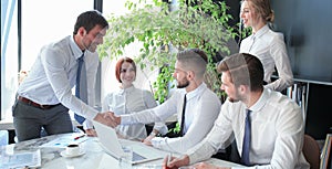 Businessman shaking hands to seal a deal with his partner and colleagues in office