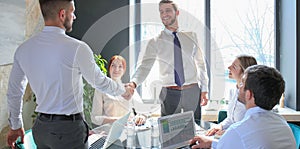 Businessman shaking hands to seal a deal with his partner and colleagues in office