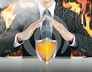 Businessman and shield with fire background