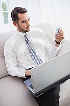 Businessman shopping online on his couch