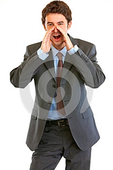 Businessman shout through megaphone shaped hand