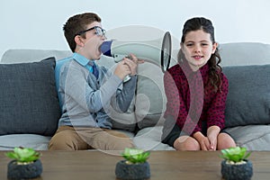 Businessman shouting through megaphone into female colleagues ear