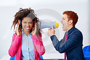 Businessman shouting megaphone to african woman