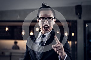 Businessman shouting and pointing finger at you because he is very angry from financial reports decreased.