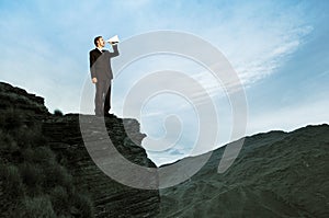 Businessman Shouting on the Top of the Mountain